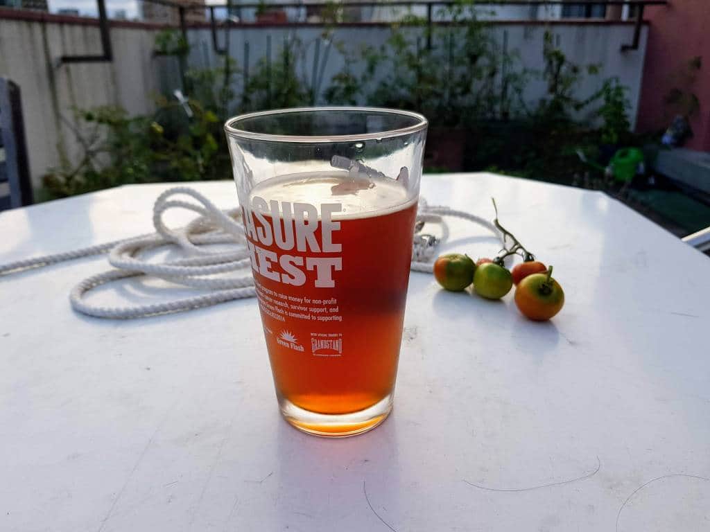 A glass of beer, outside with some tomatoes
